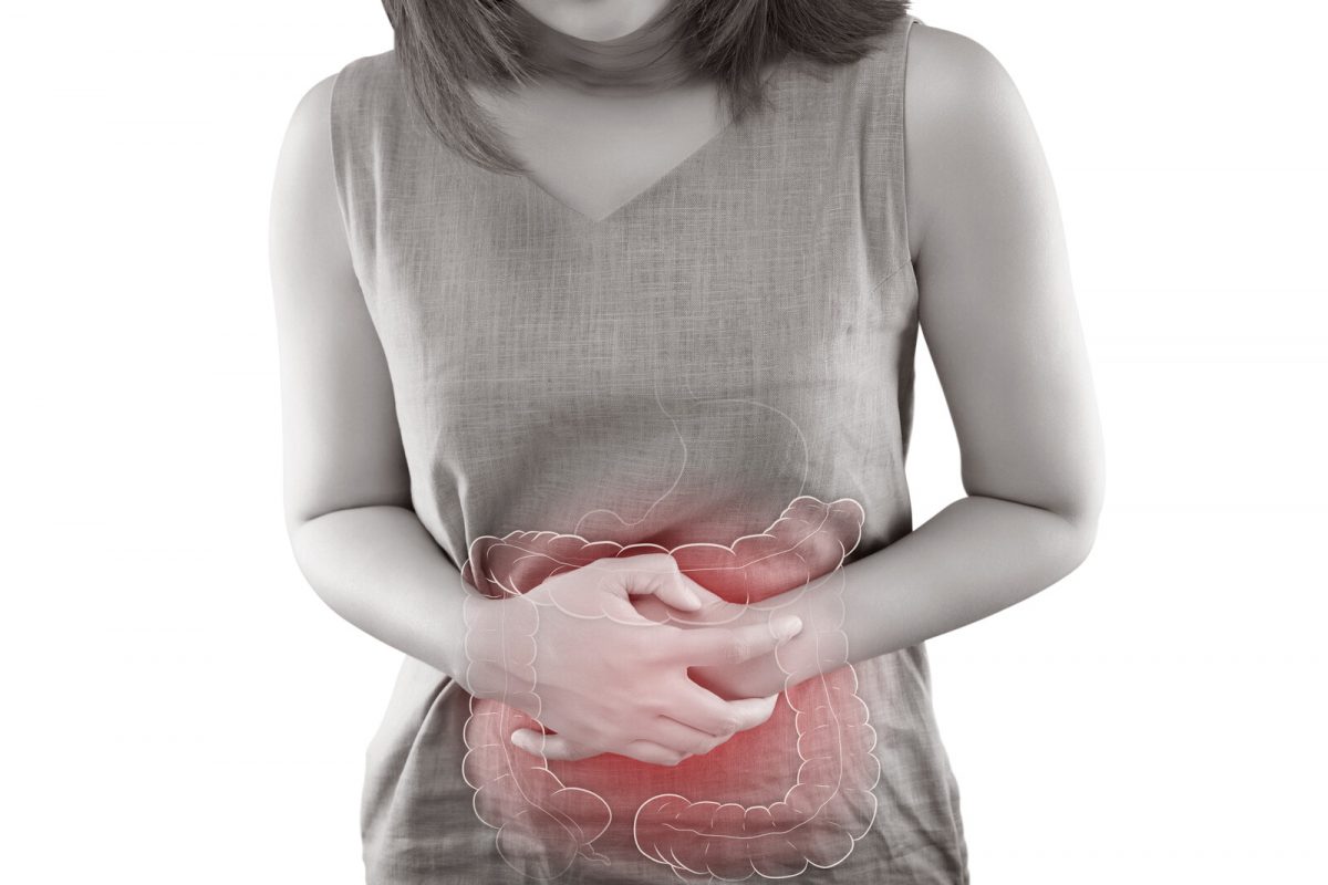 Woman holding her abdomen with a cartoon picture of the large intestine superimposed